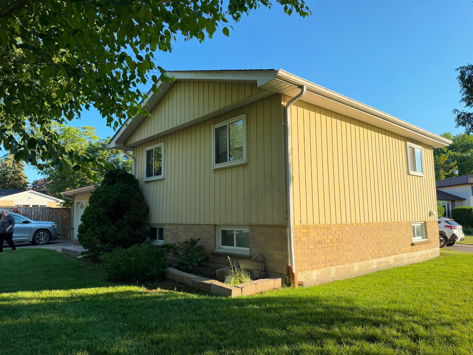 Exterior siding before photo — aged yellow aluminum siding, GTA